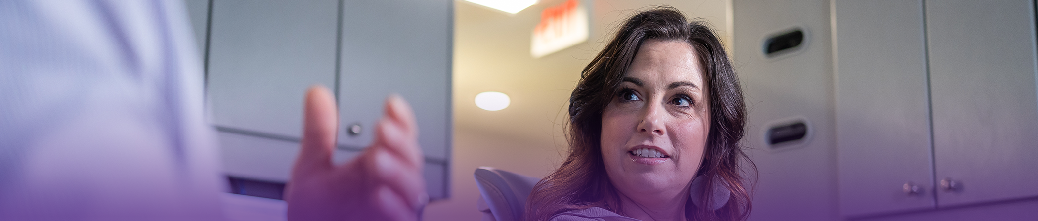 Woman in the dental chair looking up at her dentist in Keokuk