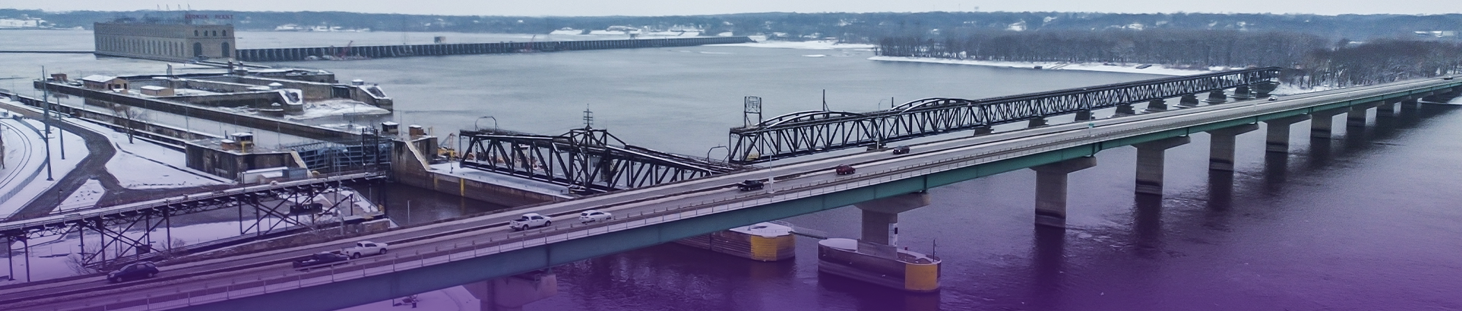 Ship sailing underneath a bridge over a bay near a city